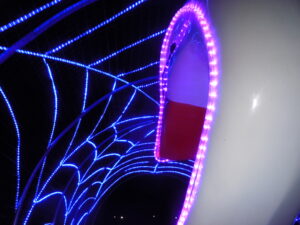 Vibrant blue and purple neon lights forming a geometric pattern on a structure at night.